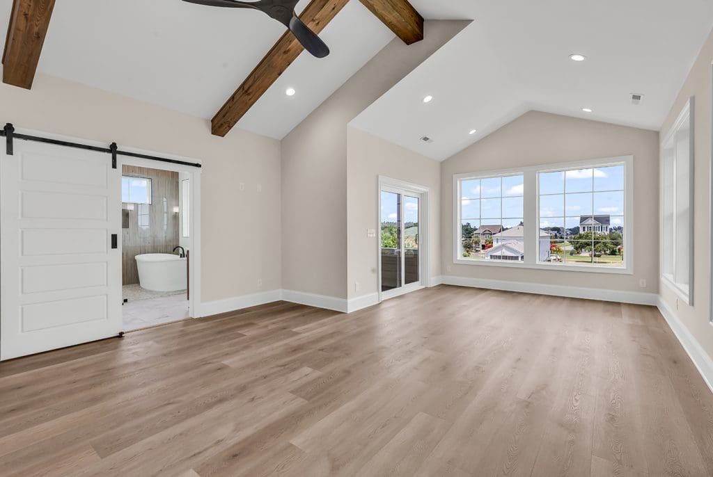 Spacious primary bedroom with vaulted ceilings and custom finishes in a Myrtle Beach new construction home.
