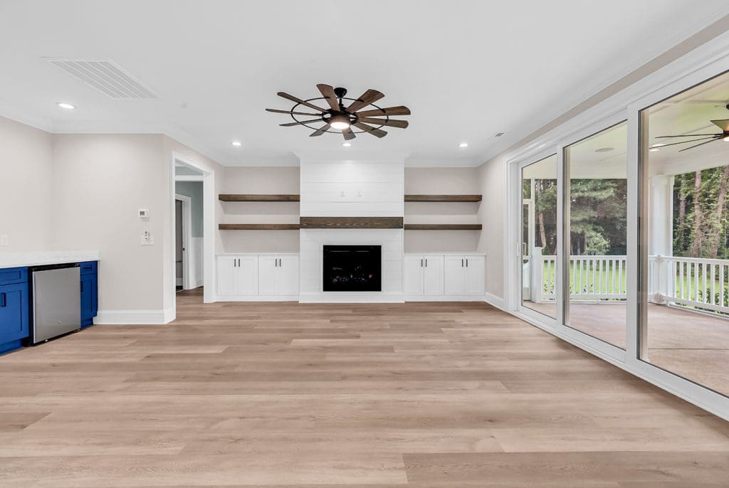 Open living room with durable flooring and built-ins designed for a low maintenance custom home.