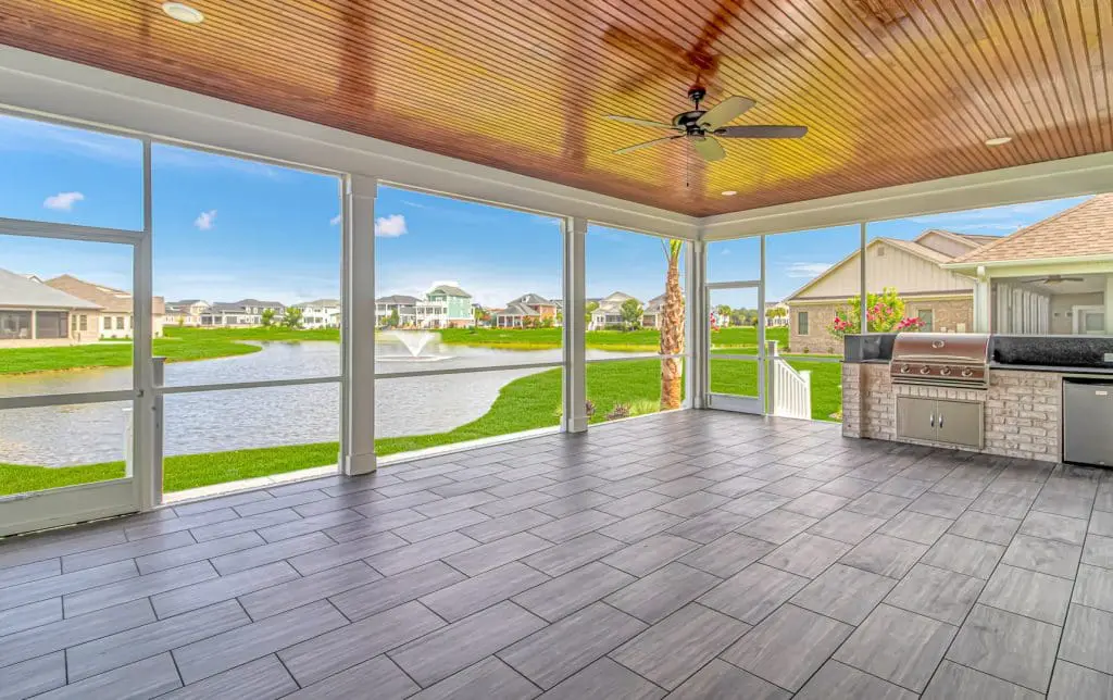 Covered patio with outdoor kitchen and pond view showcasing outdoor living space ideas.