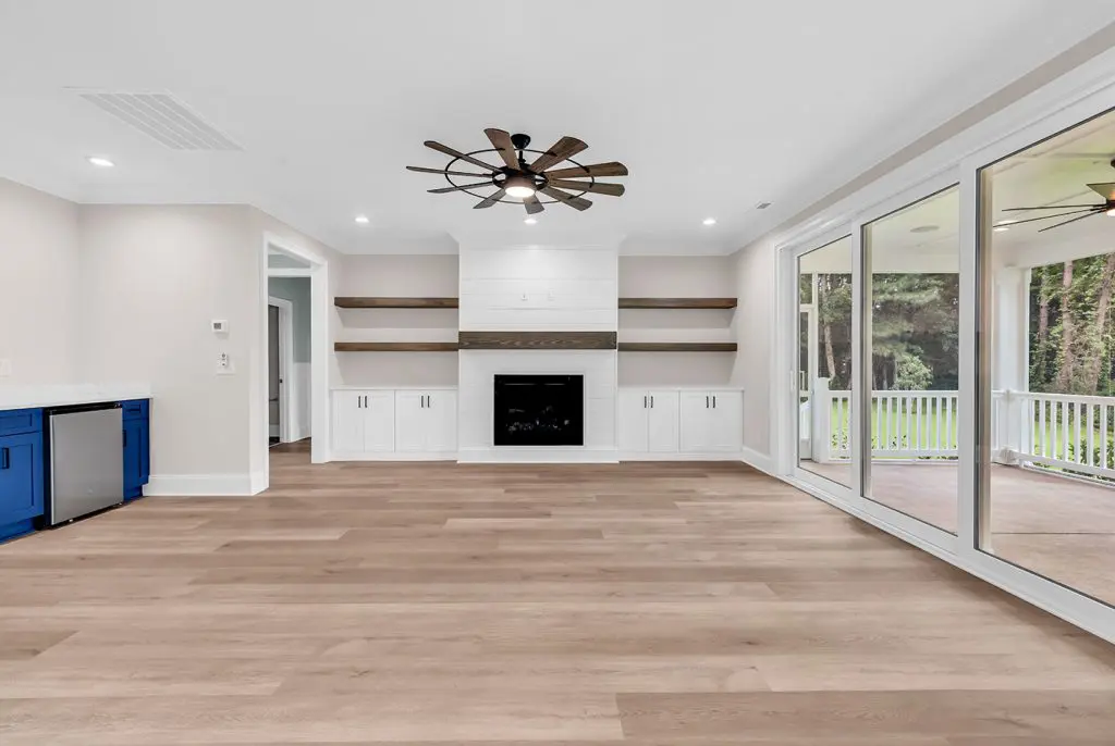 Open living room with durable flooring and built-ins designed for a low maintenance custom home.