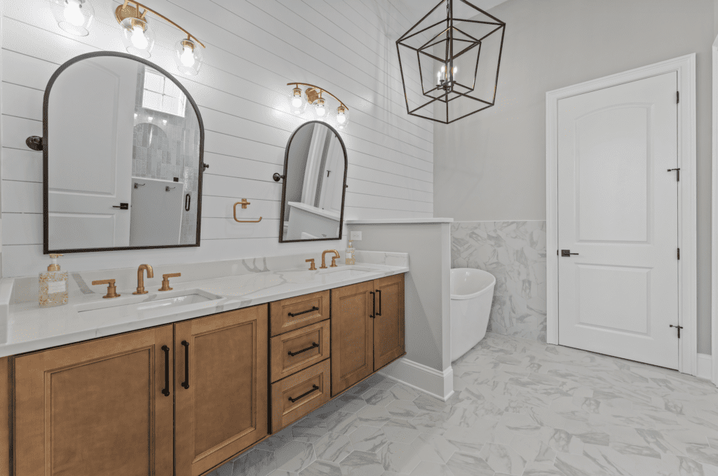 Primary bathroom featuring dual quartz vanity, custom cabinetry, freestanding soaking tub, and designer tile in a well-built luxury custom home by Swift Creek Homes in Myrtle Beach, South Carolina.