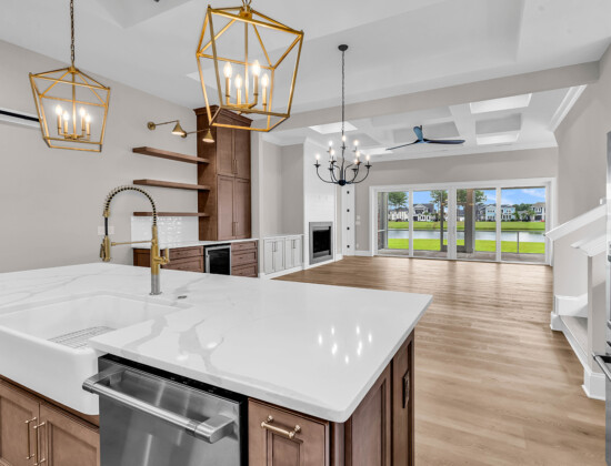 Luxury custom kitchen with quartz island, gold fixtures, and open sightlines to living areas and outdoor space in a CAPS-certified home built by Swift Creek Homes on the Grand Strand