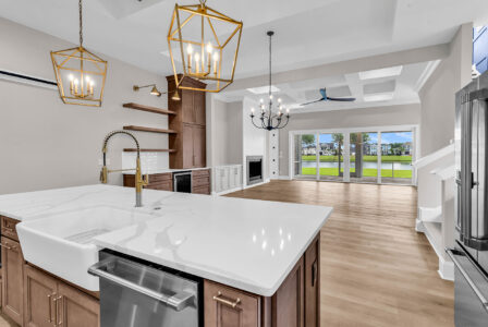 Luxury custom kitchen with quartz island, gold fixtures, and open sightlines to living areas and outdoor space in a CAPS-certified home built by Swift Creek Homes on the Grand Strand