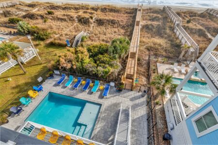 lounge chairs by pool of S Ocean home by swift creek homes