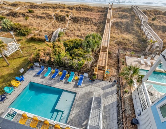 lounge chairs by pool of S Ocean home by swift creek homes