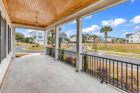 Custom home front porch featuring durable, low maintenance materials in a coastal design.