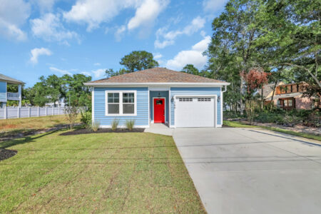 Front of a blue house with a red door